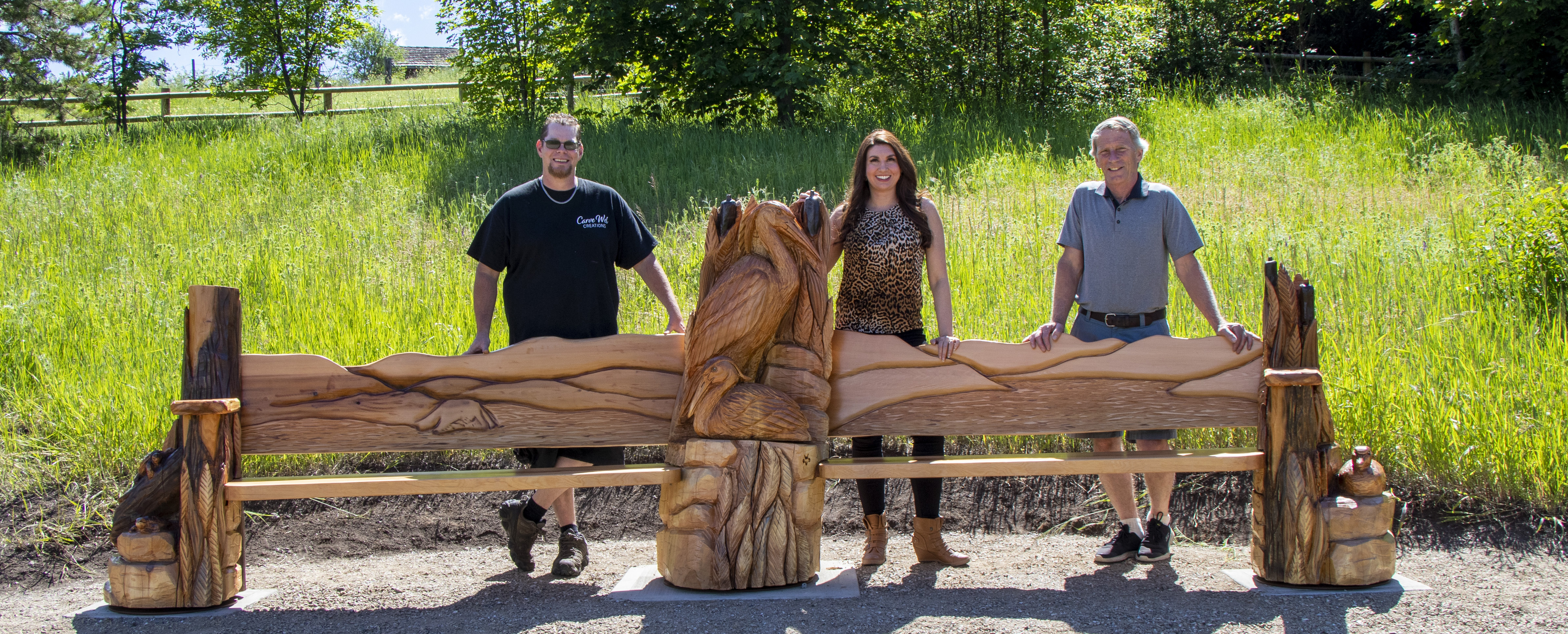Artist Tyler Welfing, Director Amanda Shatzko, and Director Bob Fleming standing at the new bench at Cools Pond