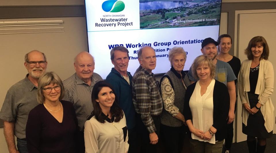 A group of people in front of the working group orientation presentation